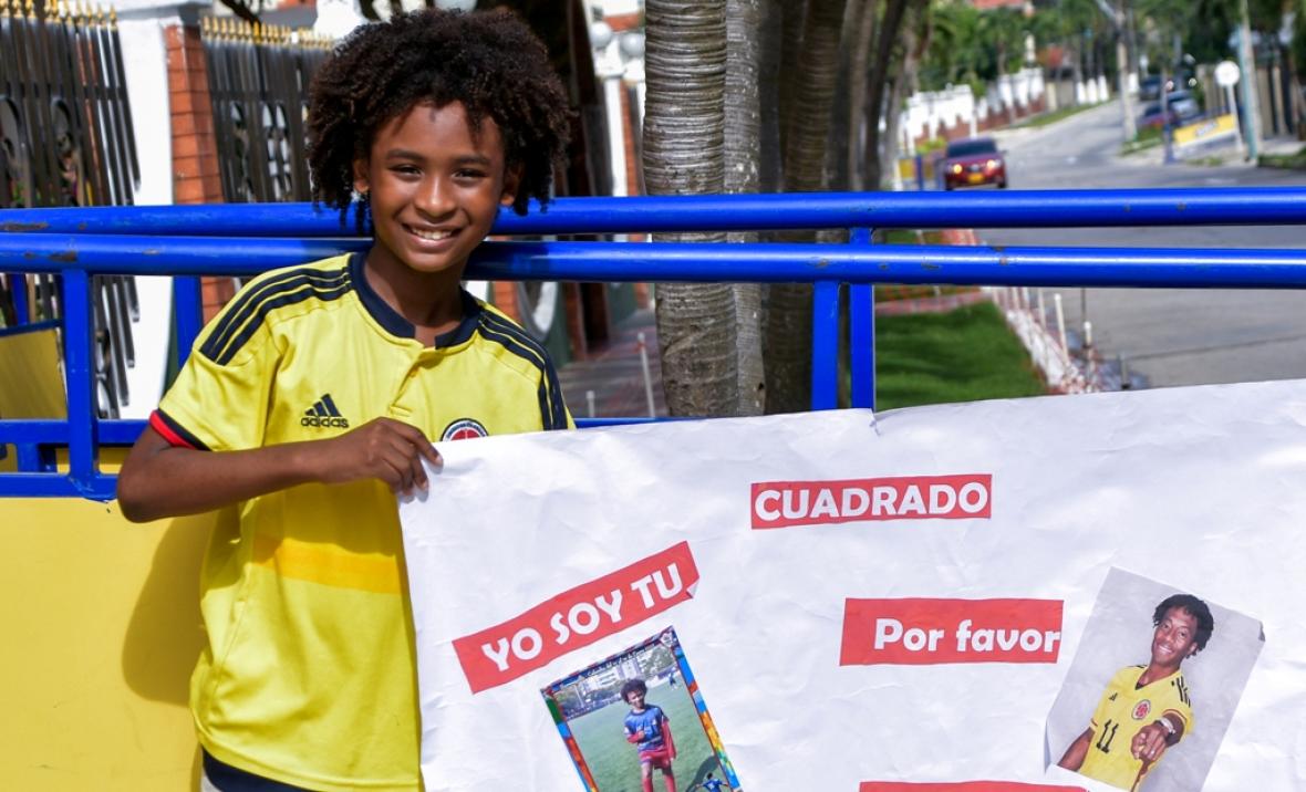 El joven Isaac con una cartelera para llamar la atención del jugador del Inter