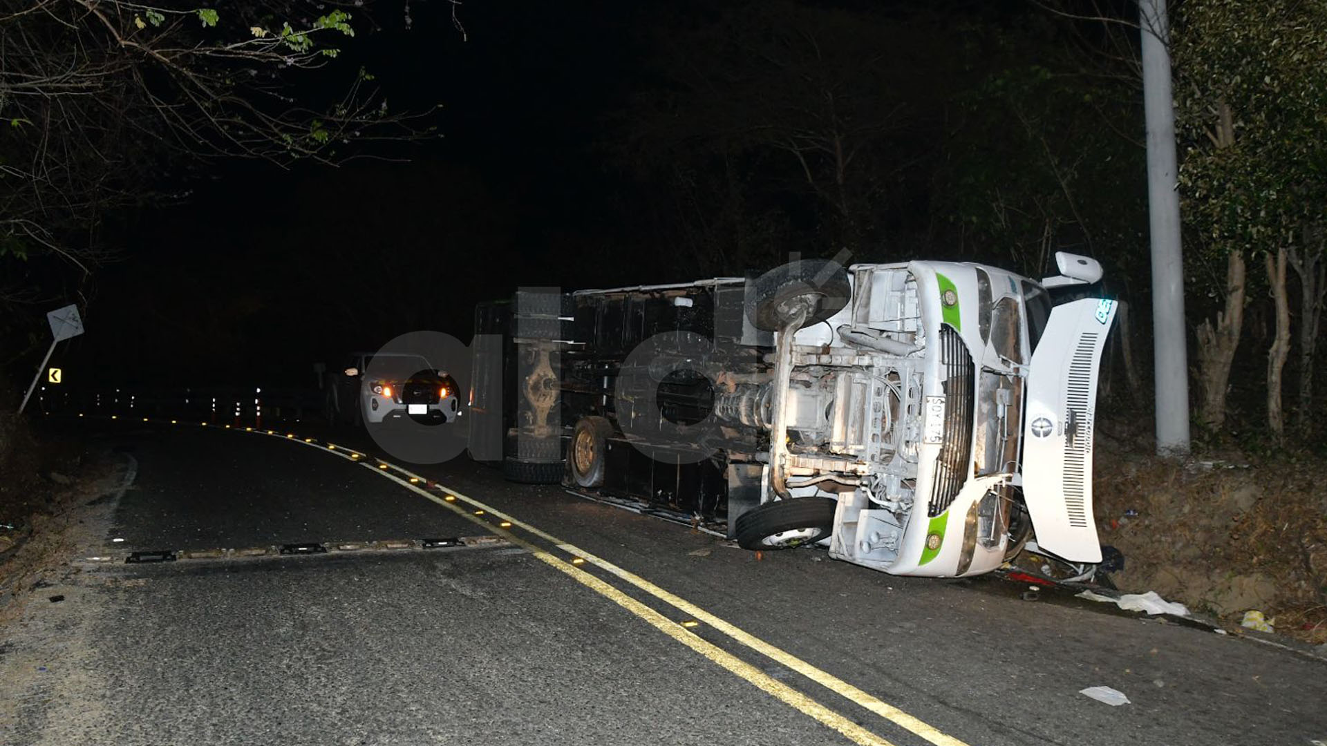 El bus volcado a un lado de la carretera tras el trágico hecho